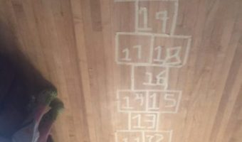 An indoor hopscotch area created with masking tape.